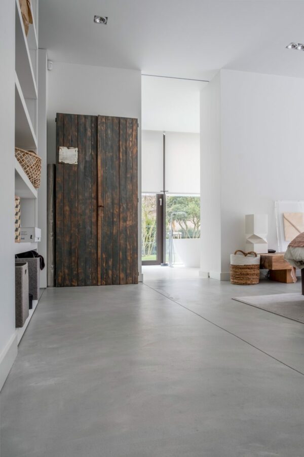 Sol en béton intérieur lissé manuellement dans une villa contemporaine avec finition gris clair