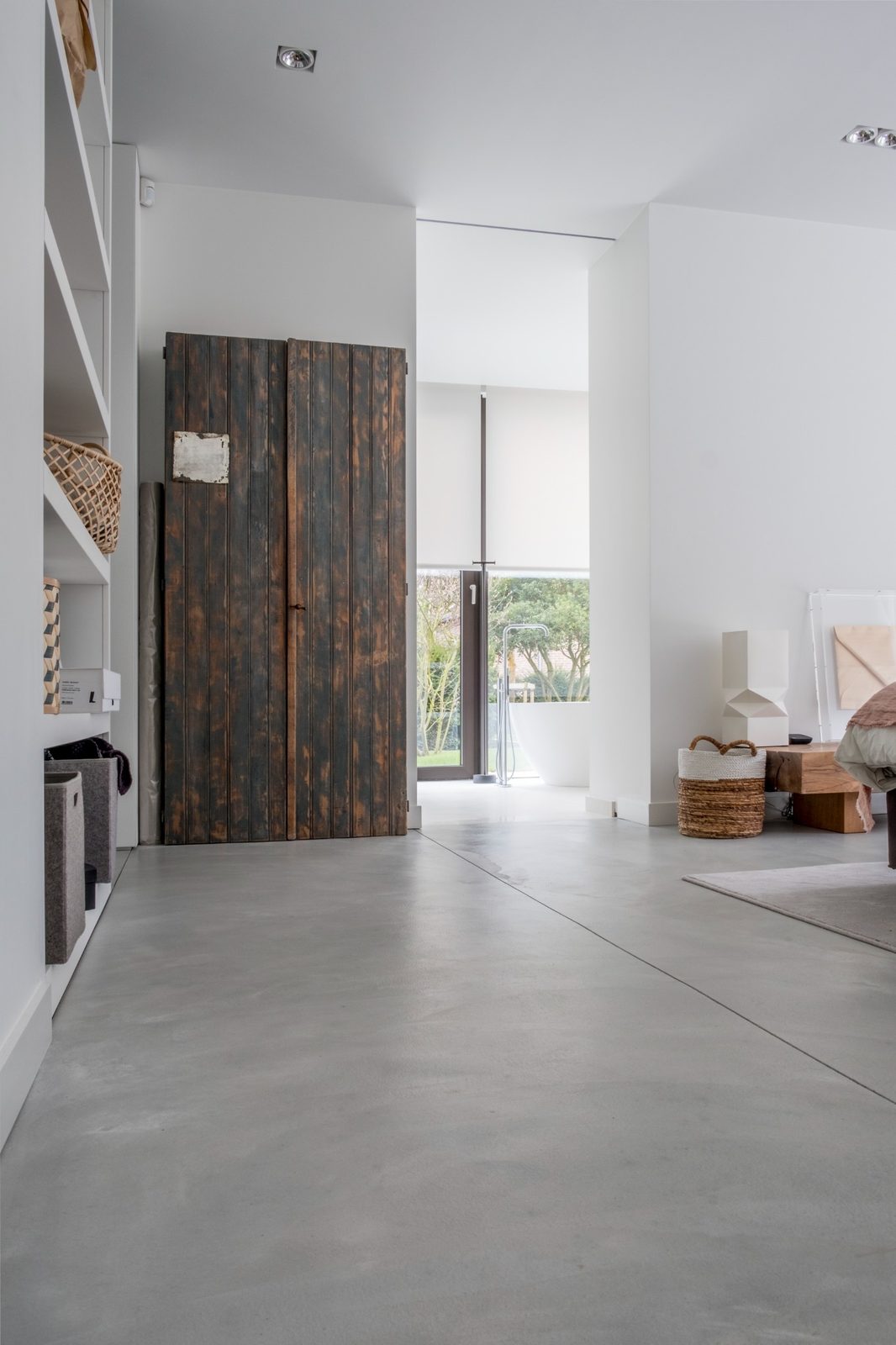 Sol en béton intérieur lissé manuellement dans une villa contemporaine avec finition gris clair