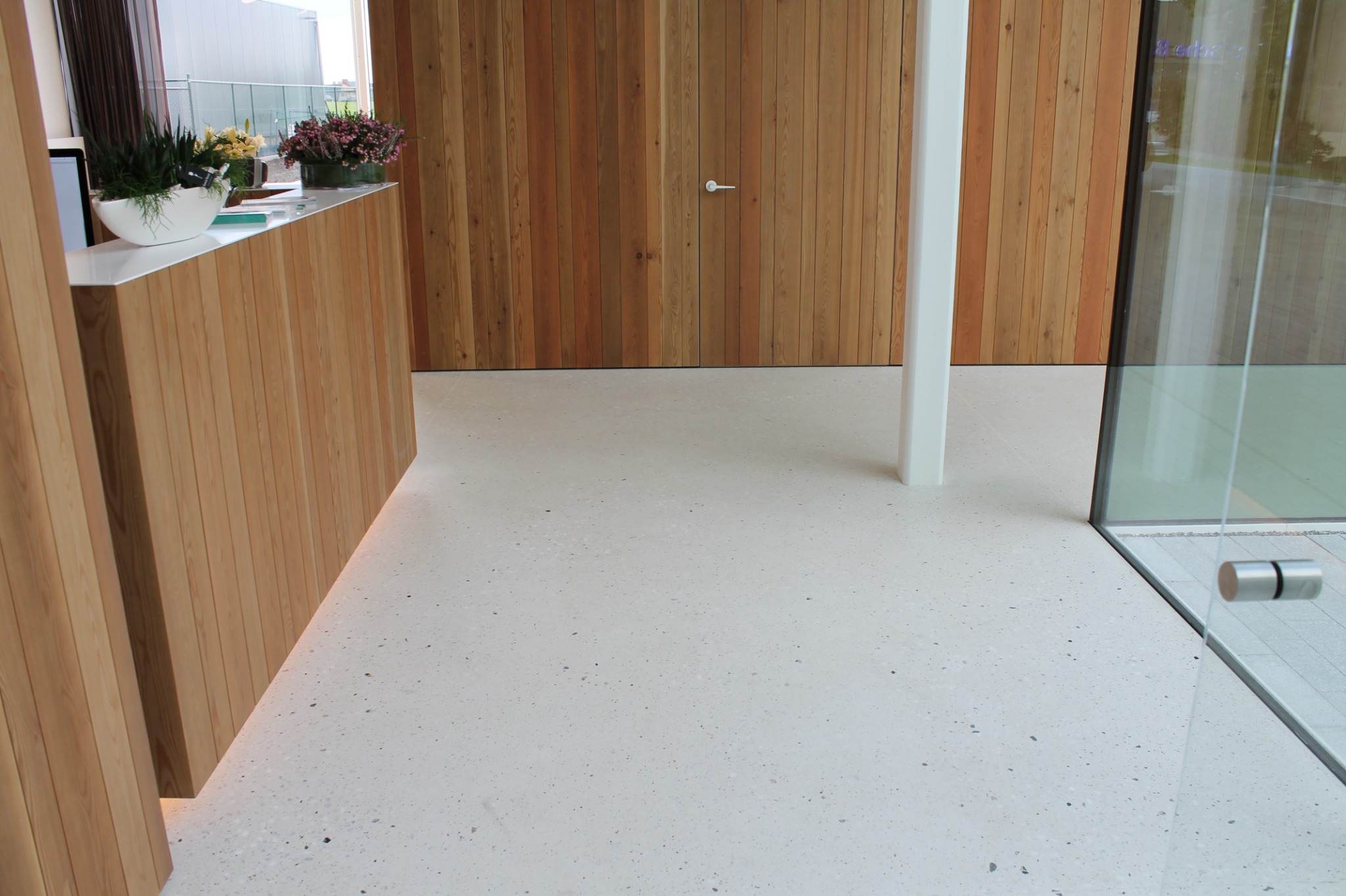 Sol en terrazzo clair dans un espace d’attente du projet Tandens à Roeselare