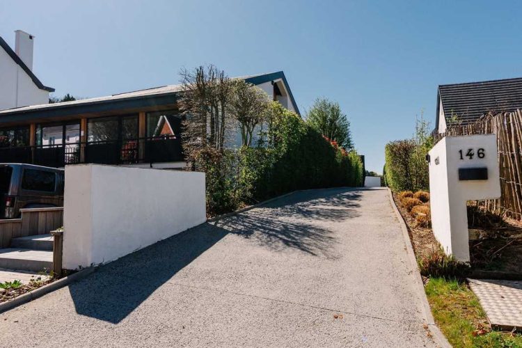 Washed concrete driveway for house surrounds landscaping in Brussels