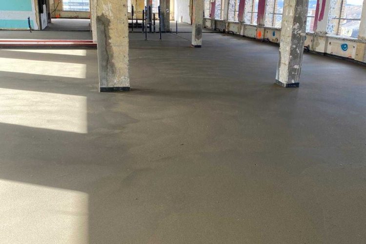 Traditional screed being applied in a large interior floor space in Brussels