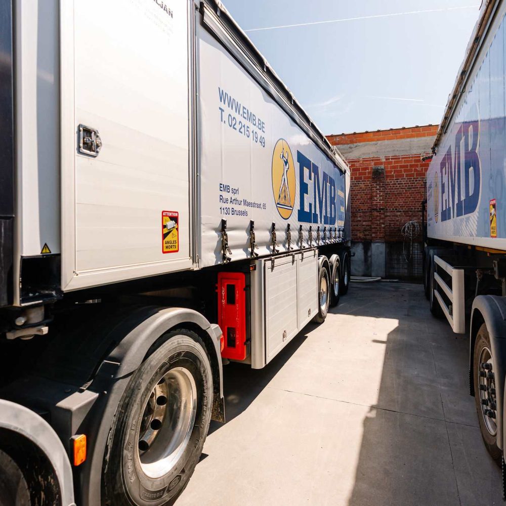 EMB trucks parked in the Brussels warehouse with markings for screeds, insulation, and concrete floors services