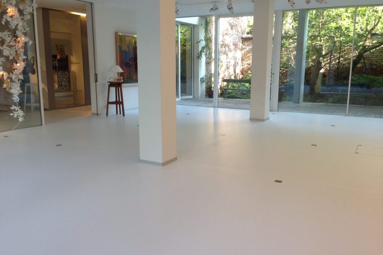 White resin floor in a bright room with large bay windows in Brussels